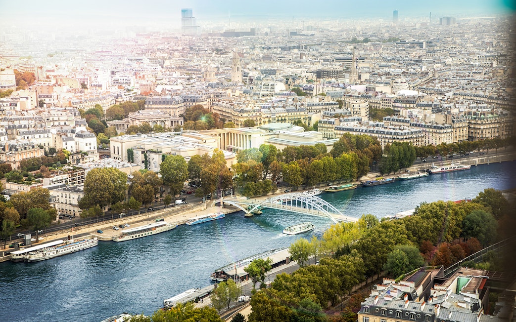 Aerial view of Seine River with Batobus boats and Paris cityscape.