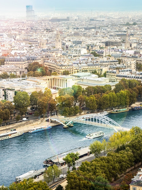 Aerial view of Seine River with Batobus boats and Paris cityscape.