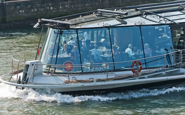 Seine River cruise with Bateaux Parisiens, guests dining with wine and live music in Paris.