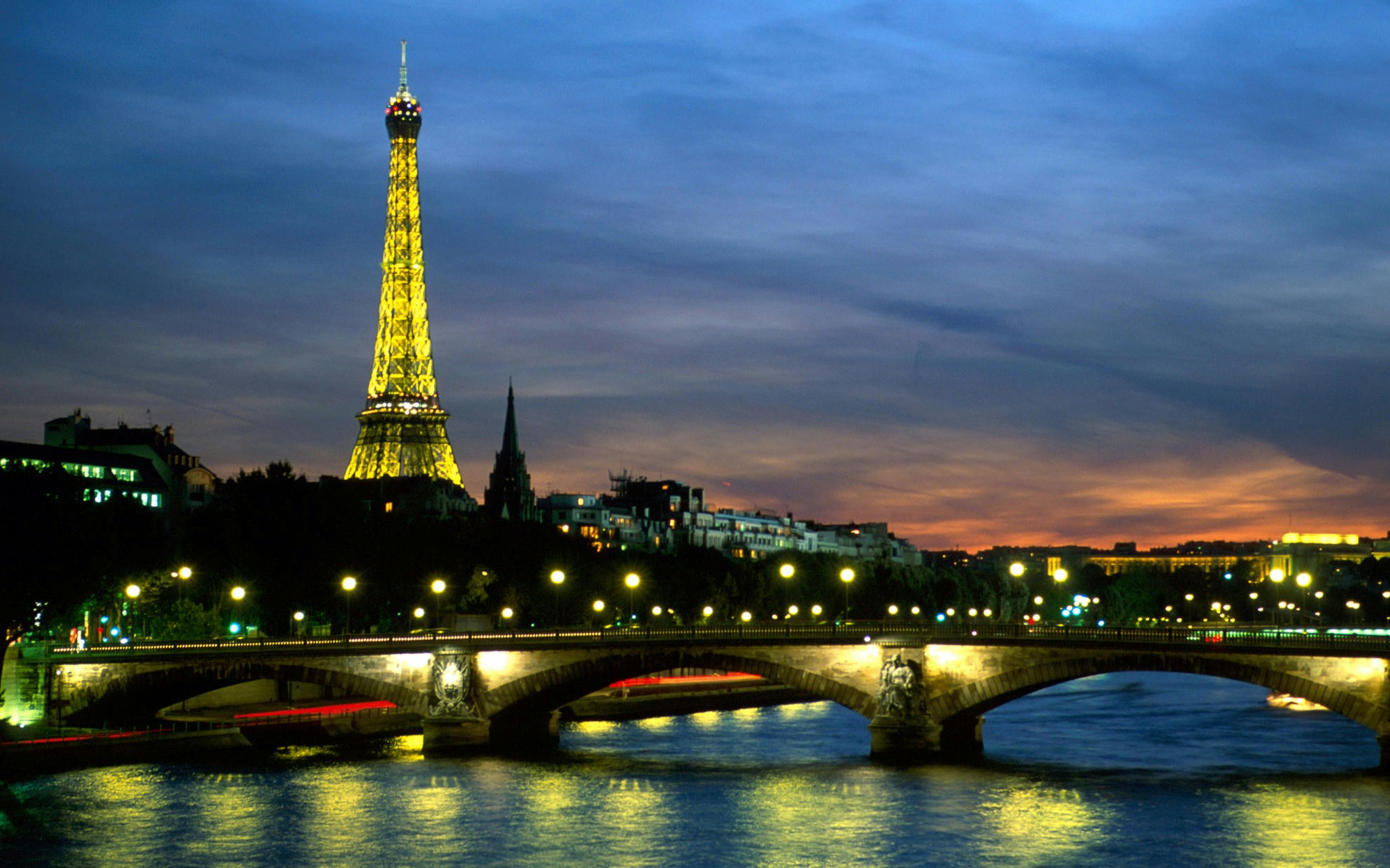 Seine River dinner cruise with illuminated Eiffel Tower view, Paris.