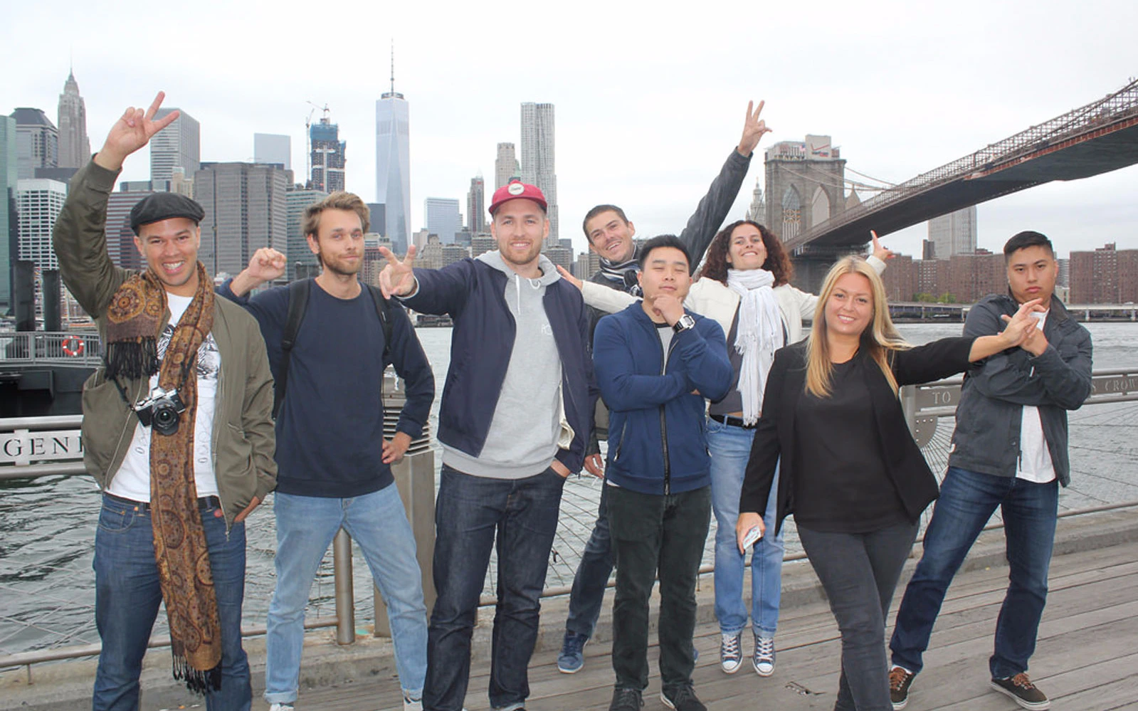Group of tourists posing with Brooklyn Bridge in the background on the 'Where Brooklyn At?' Bus Tour.
