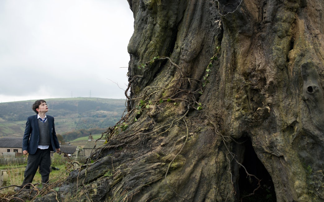 Stage performance of "A Monster Calls 2D" with actors in dramatic scene.