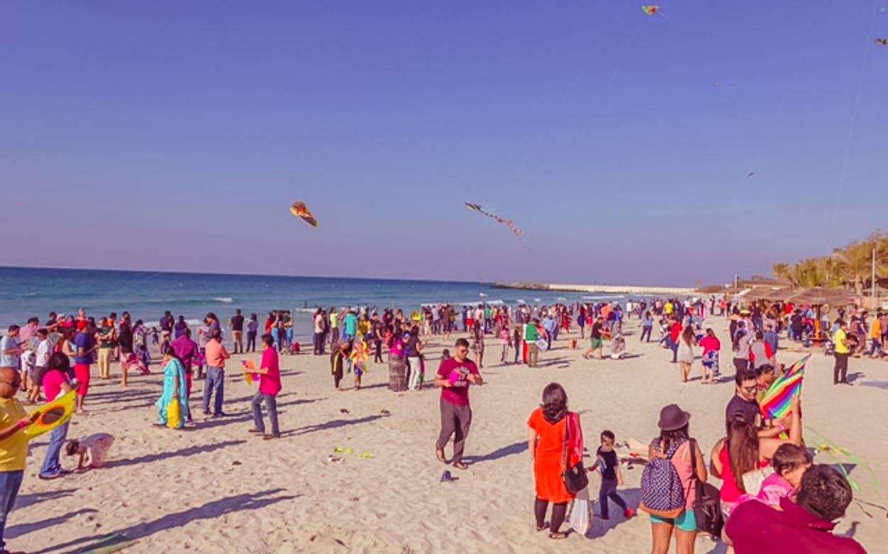 Crowd flying kites on a beach during the Bukhara Kite Festival.