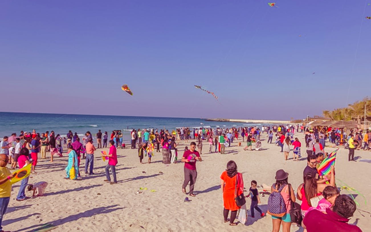 Crowd flying kites on a beach during the Bukhara Kite Festival.