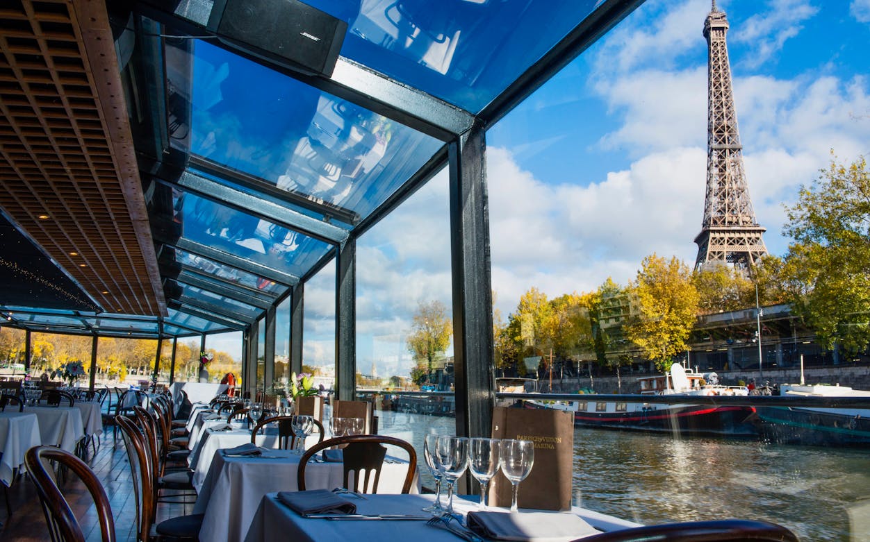 Dining area on Seine River cruise with Eiffel Tower view in Paris.