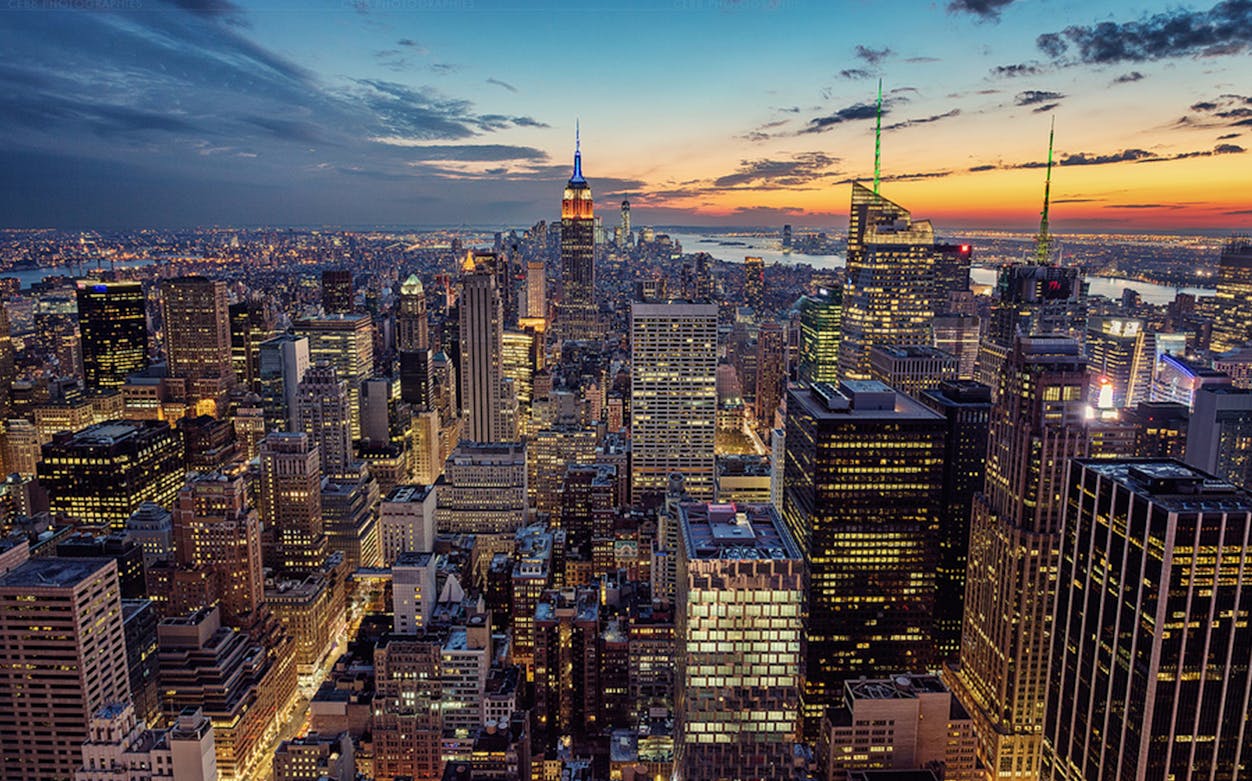 New York City skyline at sunset with Empire State Building and skyscrapers.