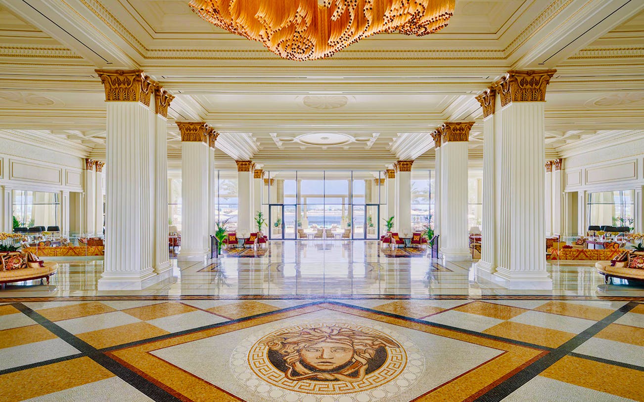 Palazzo Versace's Mosaico Lobby Lounge with elegant columns and intricate floor mosaic.