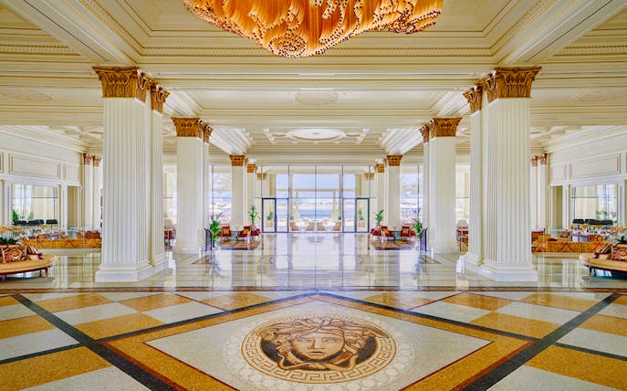 Palazzo Versace's Mosaico Lobby Lounge with elegant columns and intricate floor mosaic.