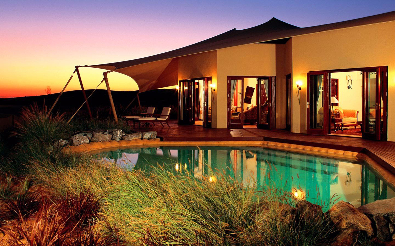 Al Maha Resort villa with private pool at sunset in the Dubai desert.