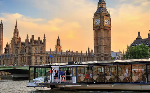 Cruise boat on the River Thames with view of Big Ben and Houses of Parliament, London.