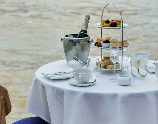 Afternoon tea setup with pastries and champagne on a cruise table.