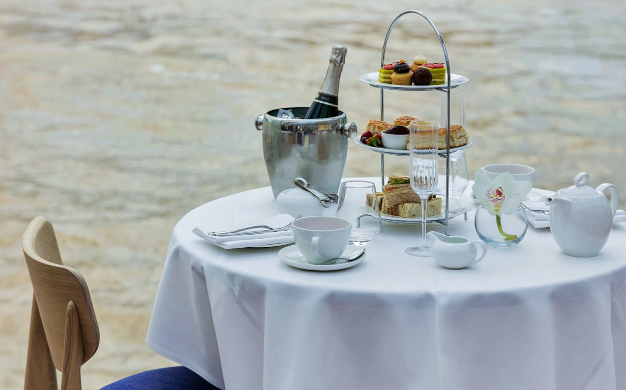 Afternoon tea setup with pastries and champagne on a cruise table.