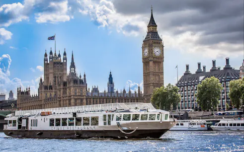 Cruise boat on River Thames with Big Ben and Houses of Parliament in London.