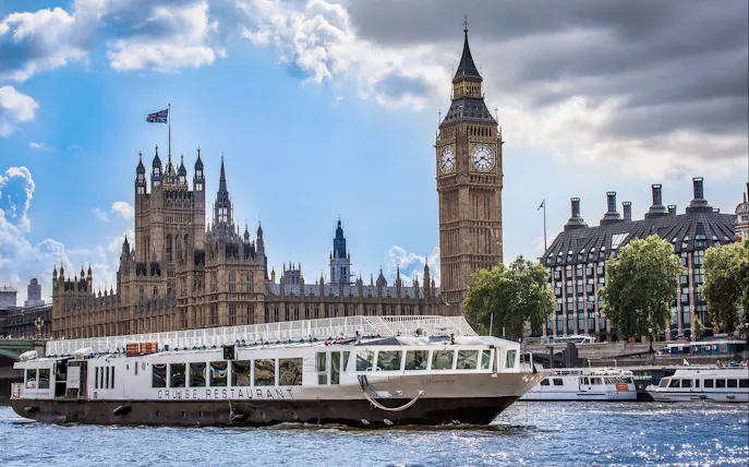 Cruise boat on River Thames with Big Ben and Houses of Parliament in London.