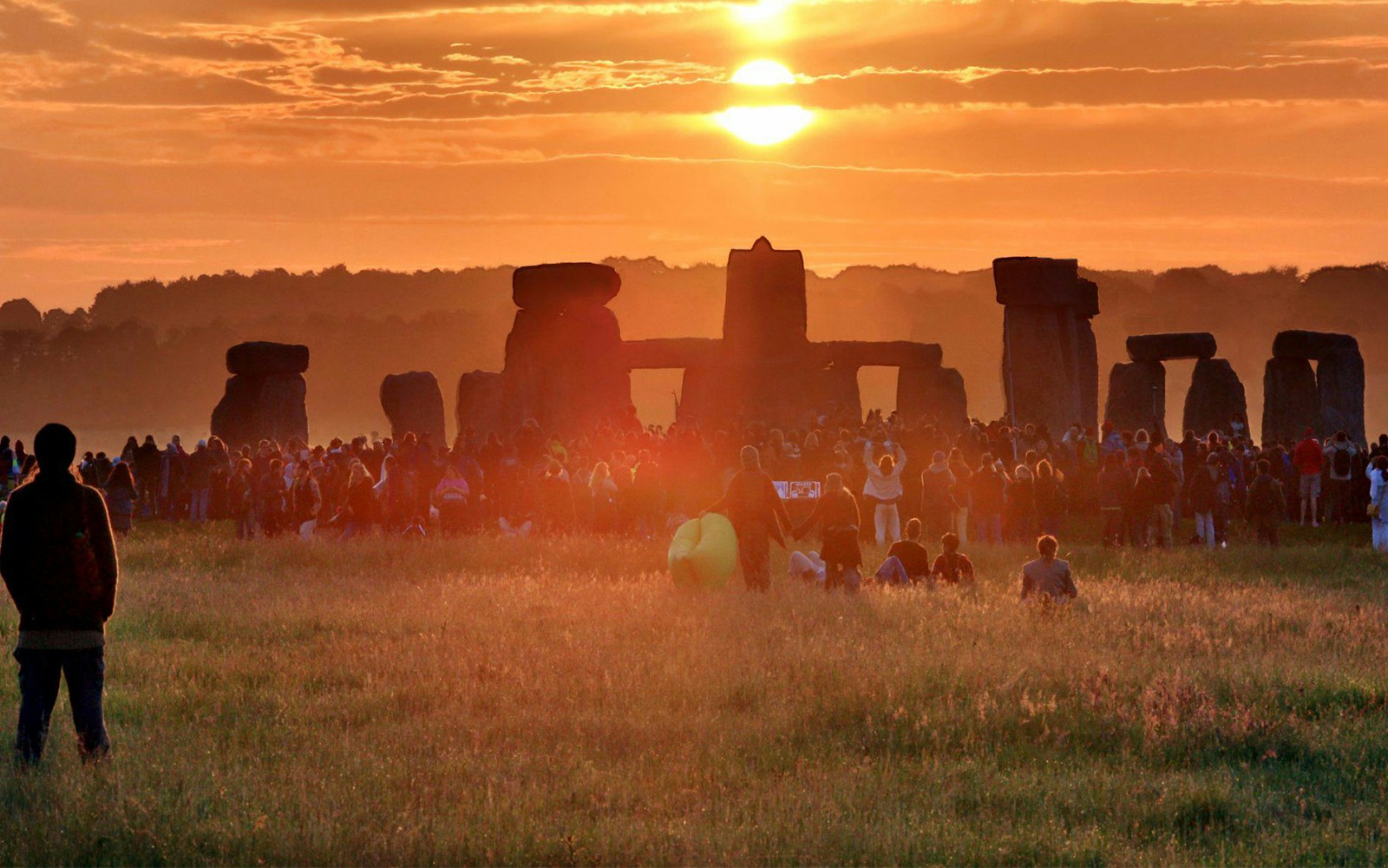Crowd gathered at Stonehenge during sunset, Wiltshire, England.