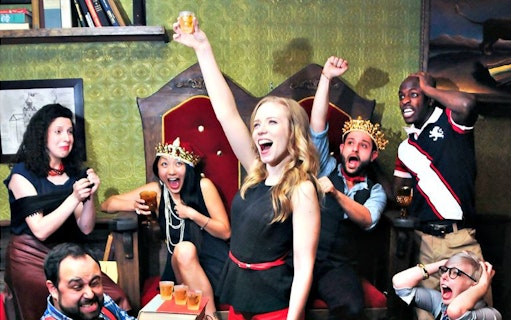 Group of actors celebrating during a Drunk Shakespeare performance in a lively setting.