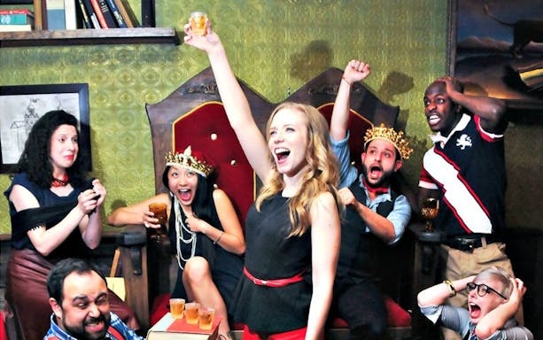 Group of actors celebrating during a Drunk Shakespeare performance in a lively setting.