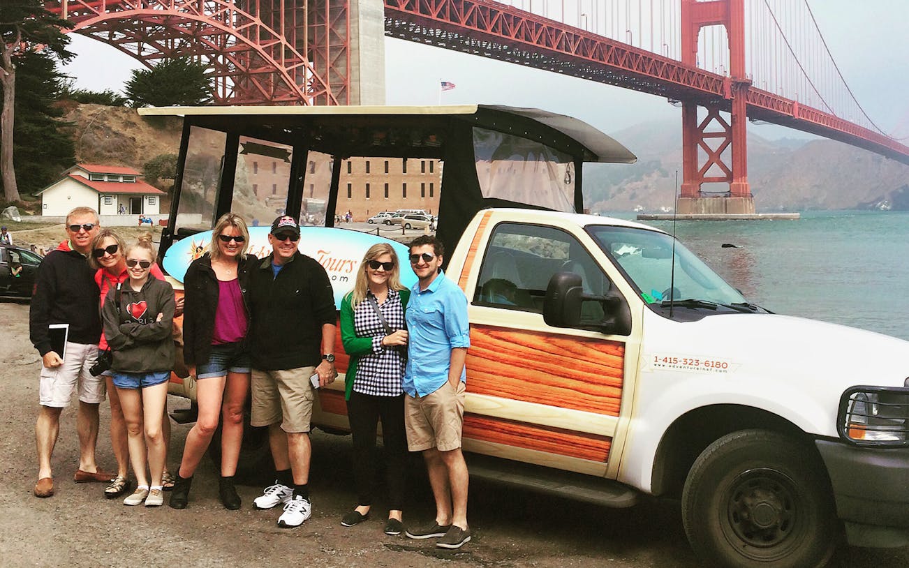 Group enjoying Beers & Bites Adventure near Golden Gate Bridge with tour vehicle.