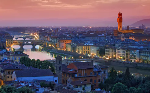 Florence skyline at sunset with Ponte Vecchio and Palazzo Vecchio, viewed from a high-speed train day trip from Rome.