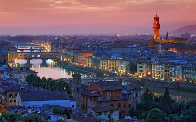 Florence skyline at sunset with Ponte Vecchio and Palazzo Vecchio, viewed from a high-speed train day trip from Rome.