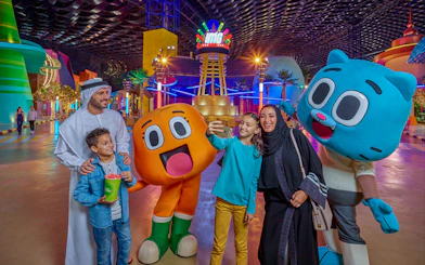 Visitors at IMG Worlds of Adventure entrance with cartoon characters in Dubai.