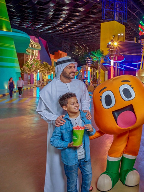 Visitors at IMG Worlds of Adventure entrance with cartoon characters in Dubai.