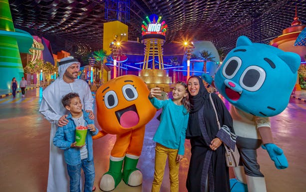 Visitors at IMG Worlds of Adventure entrance with cartoon characters in Dubai.