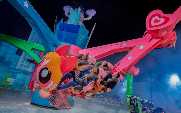 Riders enjoying a colorful spinning ride at IMG Worlds of Adventure.