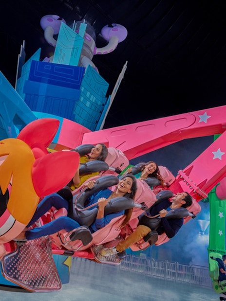 Riders enjoying a colorful spinning ride at IMG Worlds of Adventure.