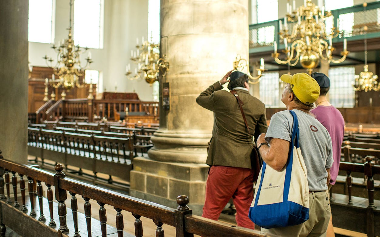 Visitors exploring a historic synagogue in the Jewish Cultural Quarters tour.