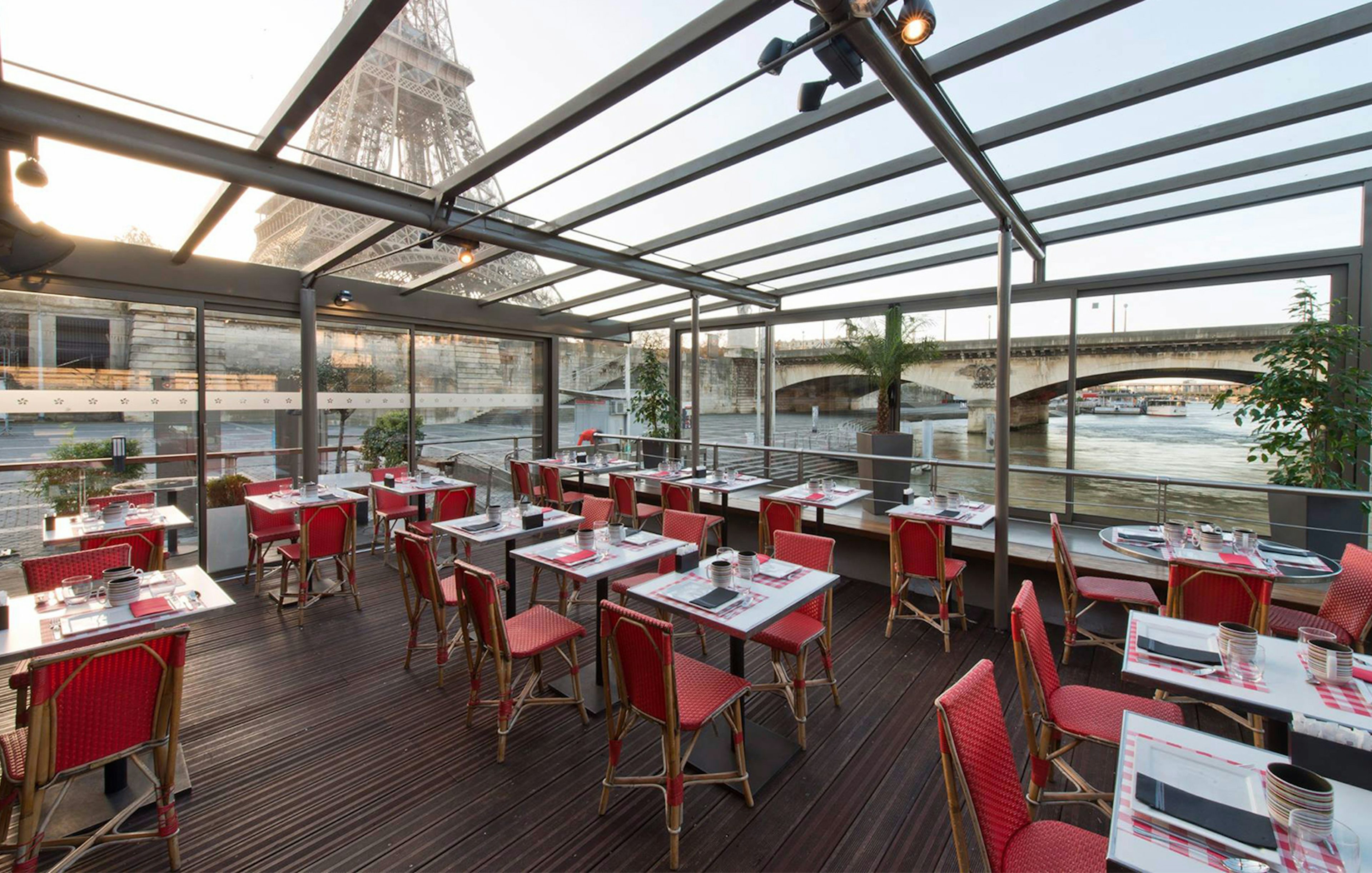 Le Bistro Parisien dining area with Eiffel Tower view, near Seine River, Paris.