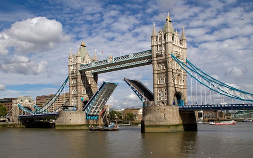 Tower Bridge in London with raised bascules, viewed from the River Thames.
