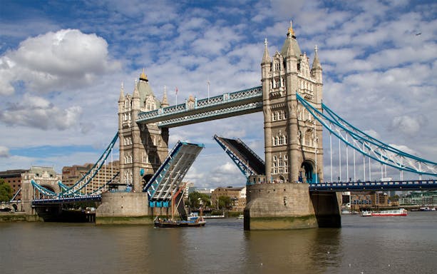 Tower Bridge in London with raised bascules, viewed from the River Thames.