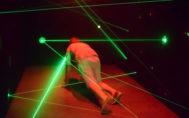 Person navigating a laser maze at Ripley's Believe It or Not attraction.
