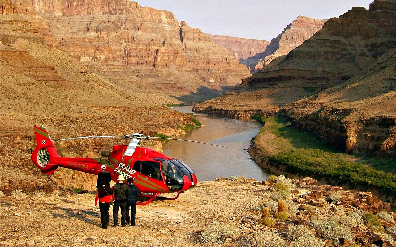 Helicopter on Grand Canyon West Rim with tourists overlooking the Colorado River.