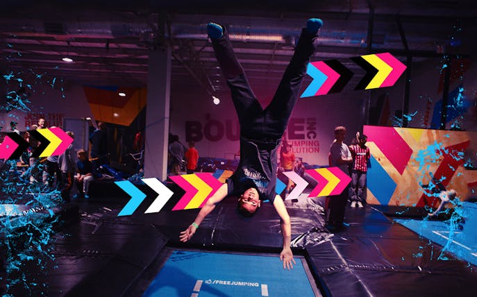 Person doing a handstand on a trampoline at Bounce Dubai indoor park.