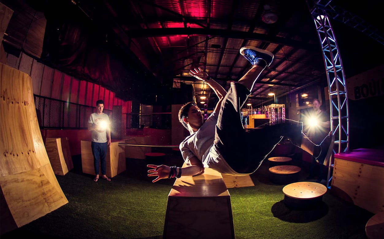 Person performing parkour at Bounce Dubai indoor trampoline park.