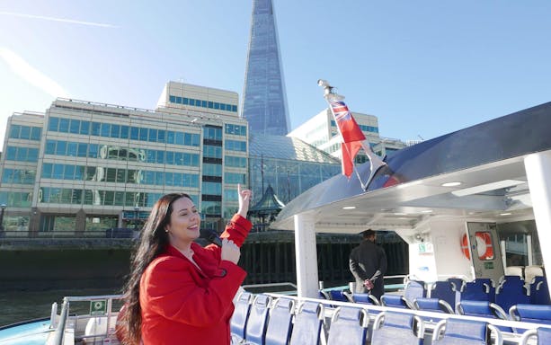 Person on Thames cruise pointing at The Shard in London.
