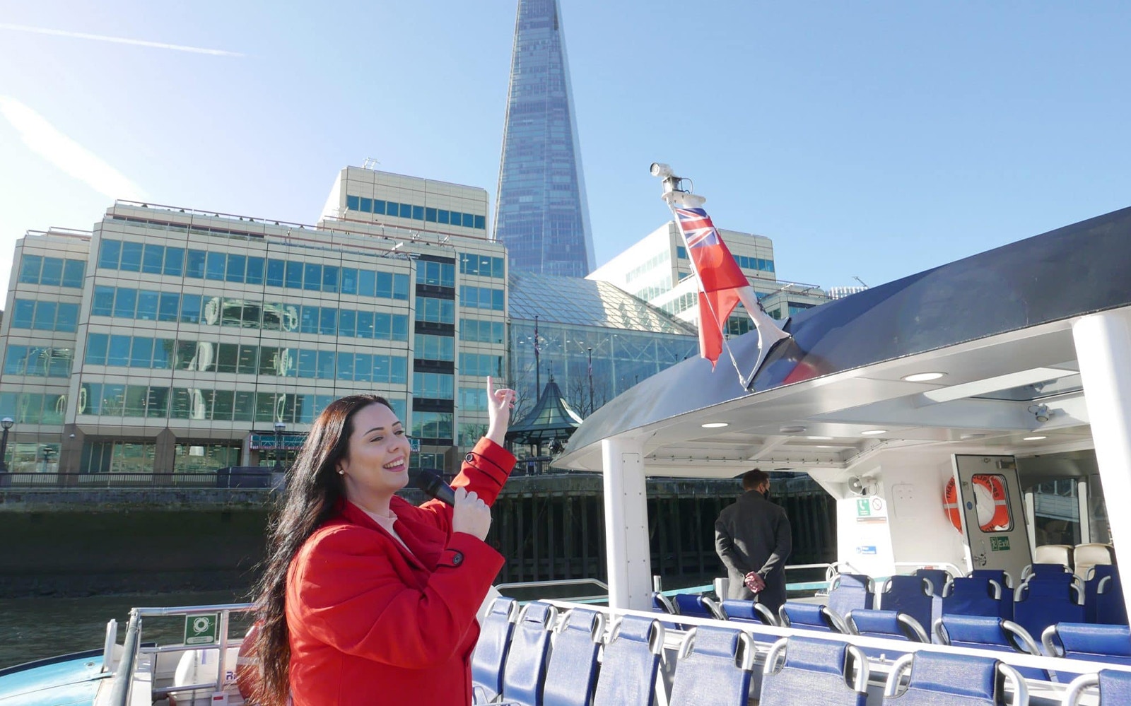 Cruise passenger pointing at The Shard from Thames River boat in London.