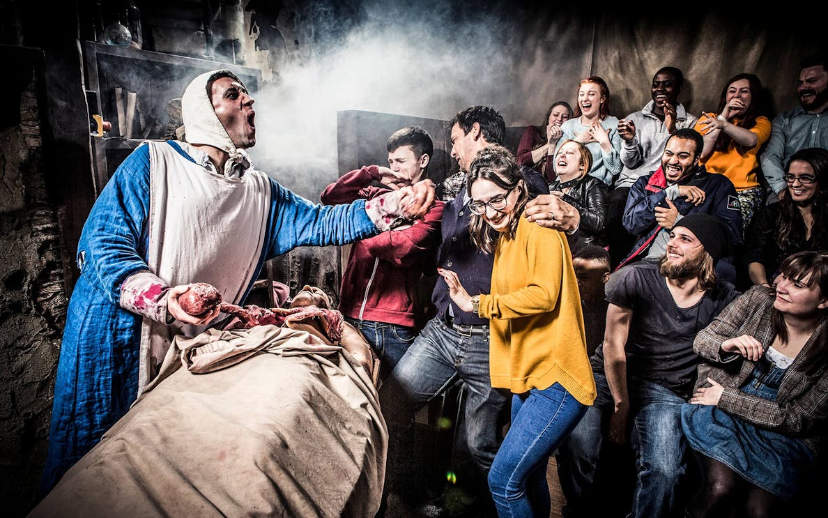 Visitors react to a live performance at The London Dungeon.