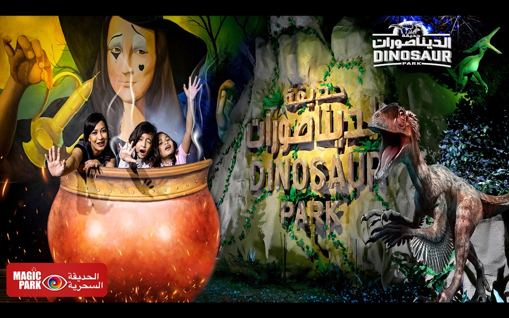Visitors at Magic Park Dubai in a cauldron with Dinosaur Park sign.