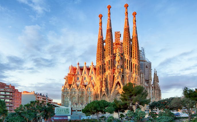 Sagrada Familia in Barcelona with sunset lighting on its intricate towers.