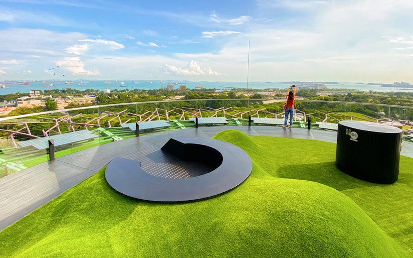 Supertree Observatory view with lush greenery and distant ocean, Singapore.