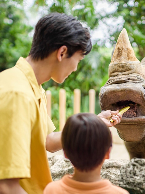 Family feeding a rhino at Singapore Zoo.