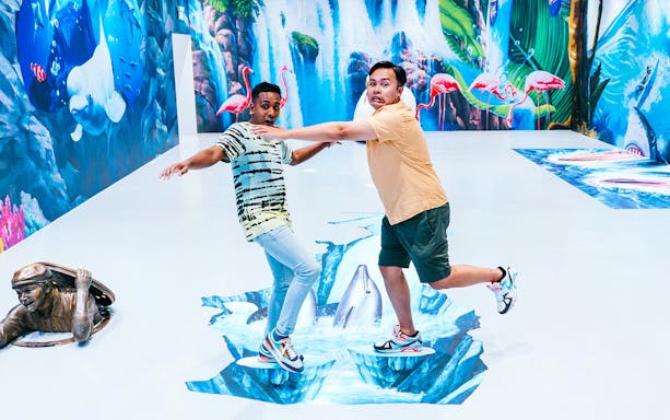 Visitors interacting with 3D art at Singapore Trick Eye Museum.