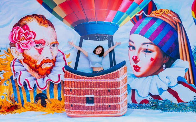 Person posing in a hot air balloon mural at Singapore Trick Eye Museum.