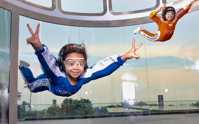 Participants enjoying indoor skydiving at iFly Singapore in a vertical wind tunnel.