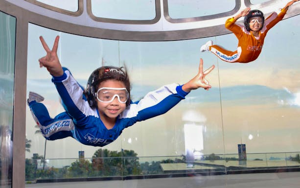 Participants enjoying indoor skydiving at iFly Singapore in a vertical wind tunnel.
