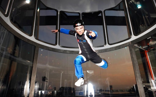 Participant in wind tunnel at iFly Singapore indoor skydiving experience.