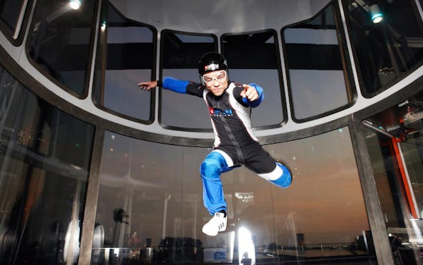 Participant in wind tunnel at iFly Singapore indoor skydiving experience.